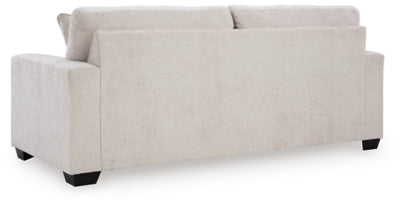 Ashley Furniture Aviemore Sofa in a neutral fabric with plush cushions and wooden legs, shown from the back.