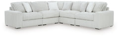 Ashley Furniture Stupendous sectional sofa with plush cushions and neutral fabric in a spacious living room setting.