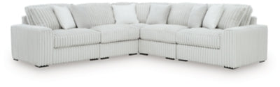 Ashley Furniture Stupendous sectional sofa with plush cushions and neutral fabric in a spacious living room setting.