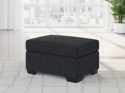 Ashley Furniture Jasmine Peaks Ottoman with plush fabric and wooden legs, showcasing a stylish, versatile ottoman design.