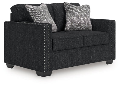Ashley Furniture Jasmine Peaks loveseat shown from an angled side view, upholstered in neutral fabric with plush cushions.