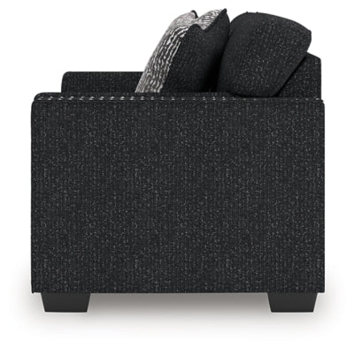 Ashley Furniture Jasmine Peaks loveseat with plush fabric and cushioned armrests, shown in a cozy living room setting.