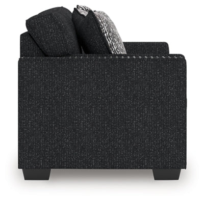 Ashley Furniture Jasmine Peaks loveseat with plush fabric and cushioned backrest, shown in a cozy living room setting.
