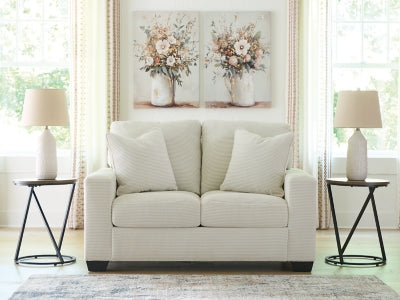 Greenbriar Ashley Furniture loveseat with plush green upholstery and cushioned armrests, ideal for cozy living room seating.