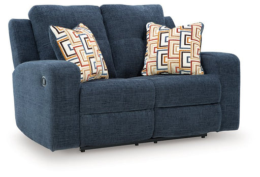 Ashley Furniture Danum reclining loveseat with plush fabric and padded armrests, shown from an angled view.