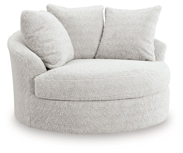 Ashley Furniture Cuddle Plush Oversized Swivel Accent Chair with soft fabric upholstery and plush cushioning, angled view.