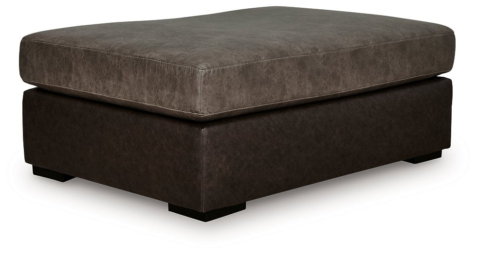 Ashley Furniture Castille Way oversized accent ottoman with plush fabric and tufted top, shown from an angled side view.