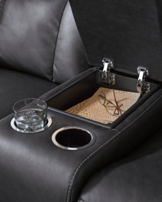 Ashley Furniture Mackmenville reclining loveseat with built-in console, featuring plush cushions and wide armrests.