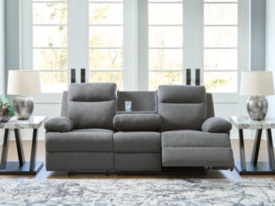 Open Ashley Furniture side-swipe reclining sofa with drop-down table, showcasing plush gray upholstery and built-in cup holders.