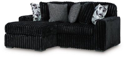 Ashley Furniture Midnight-Madness sectional with chaise, showcasing plush fabric, modern design, and spacious seating in a stylish living room