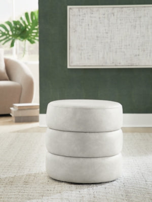 Ashley Furniture Ummi Swivel Accent Ottoman with plush fabric and a rotating base, perfect for living room decor.