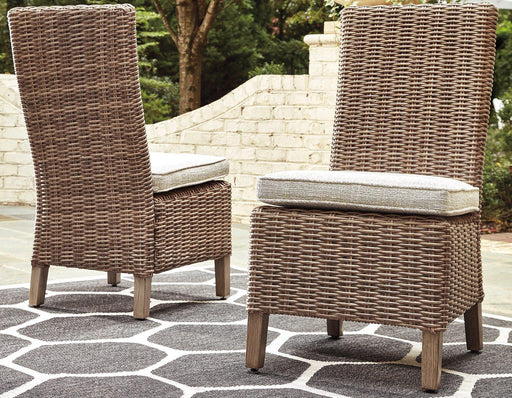 Set of two Ashley Furniture Beachcroft outdoor dining side chairs with cushions, ideal for patio or garden seating.