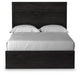 Ashley Furniture Belachime bed with a headboard featuring intricate wood design and a dark finish, shown from a front angle.