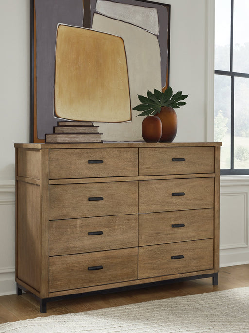 Ashley Furniture Tomtyn dresser with sleek wood finish and modern hardware, shown in a close-up of the dresser's front.