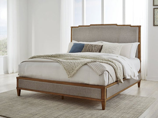 Ashley Furniture Sharlance King Upholstered Bed with tufted headboard and wooden frame in a modern bedroom setting.