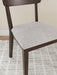 Ashley Furniture Mallenette dining chair with upholstered seat and wooden legs, shown from a detailed angle.