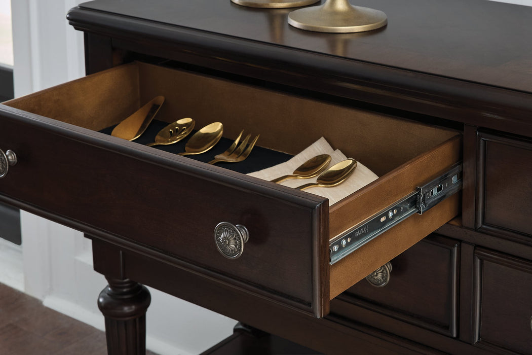 Ashley Furniture Lavinton dining server with wood finish, featuring multiple storage drawers and cabinet doors for dining room organization.