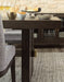 Detailed view of Ashley Furniture Burkhaus dining room set base, showcasing the sturdy wood legs and elegant design.
