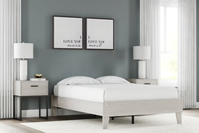 Ashley Furniture Socalle Bed in a modern bedroom setting with a wooden frame and upholstered headboard, showcasing style and comfort.