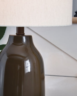 Ashley Furniture Jyler table lamp with a sleek base and fabric shade, perfect for adding style to a living room or bedroom.