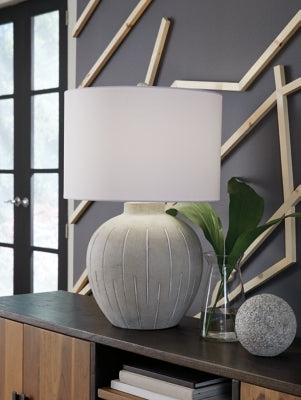 Ashley Furniture Calbert Table Lamp with fabric shade and sleek base, perfect for adding style to any room.