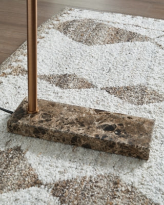 Close-up of the base of a Yafe floor lamp by Ashley Furniture, showcasing its modern design and sturdy construction.