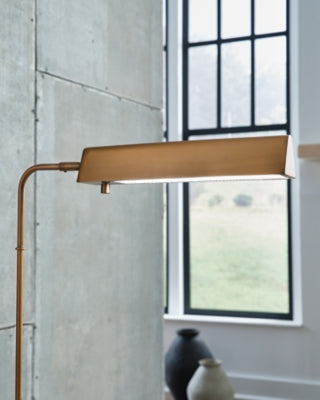 Ashley Furniture Yafe floor lamp with a sleek, modern design featuring a tall metal stand and a fabric lampshade.