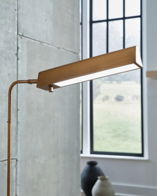 Ashley Furniture Yafe floor lamp with a sleek metal base and fabric shade, enhancing modern living room decor.