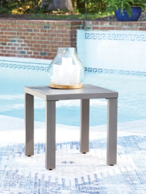 Ashley Furniture Half Moon Beach outdoor end table with a woven design and sturdy legs, perfect for patio or porch decor.