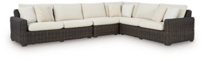 Kimora outdoor sectional by Ashley Furniture featuring plush cushions and a stylish outdoor seating arrangement.