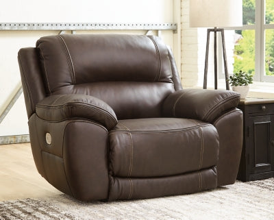 Ashley Furniture Dunleith power recliner with plush upholstery and padded armrests, shown in a closed position.
